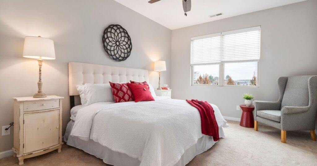 Spacious modern bedroom featuring cozy red accents and elegant decor.
