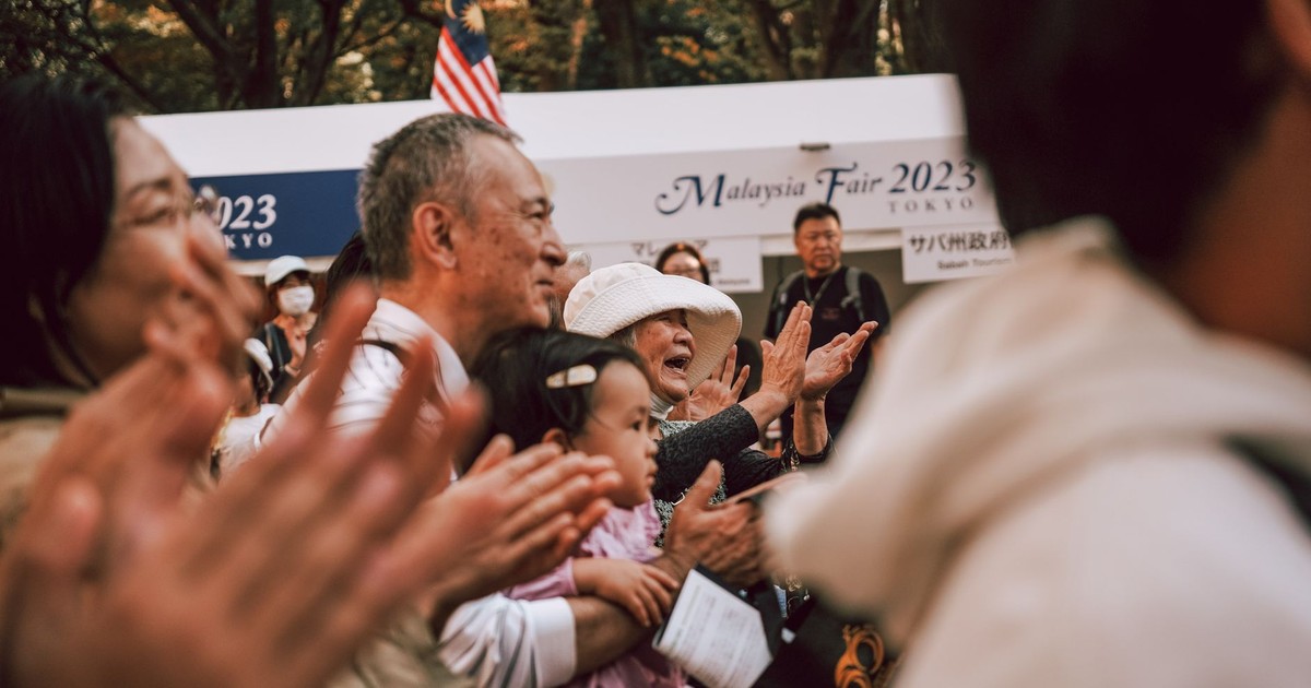 A lively crowd applauding at Malaysia Fair 2023 in Tokyo, capturing cultural celebration and unity.