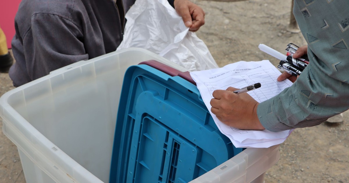 Election authorities managing ballot box during Nepal election.