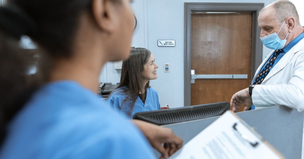 Healthcare professionals in discussion at a hospital reception, emphasizing teamwork and communication.