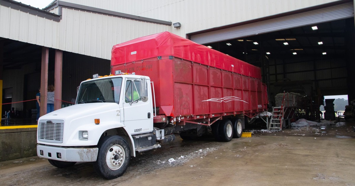 Red trailer truck at a warehouse loading dock, ready for delivery.
