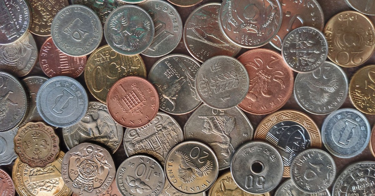 Diverse collection of world coins in a flat lay arrangement, showcasing different currencies and designs.