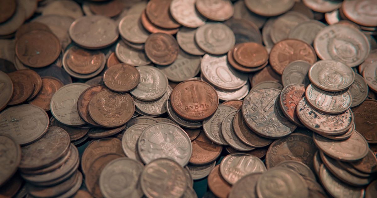 A scattered collection of various vintage coins with copper and silver tones, depicting wealth and currency.