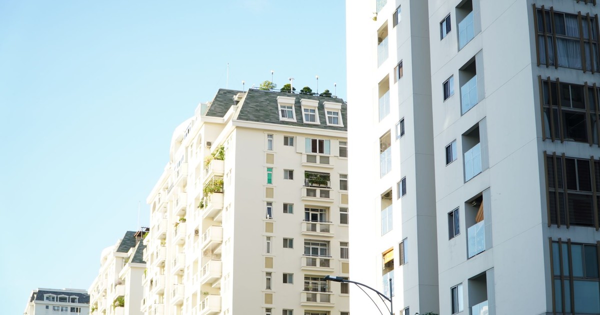 Bright day view of white urban residential apartment buildings.