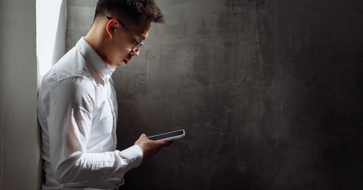 A focused businessman using a smartphone in a modern indoor setting.