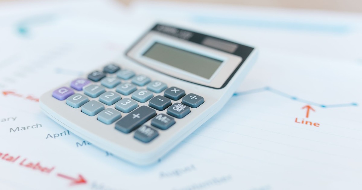 Close-up of a calculator on financial documents with graphs and analysis papers.