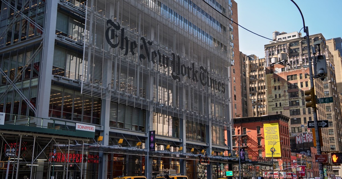 The iconic New York Times building with yellow taxis in bustling Manhattan.