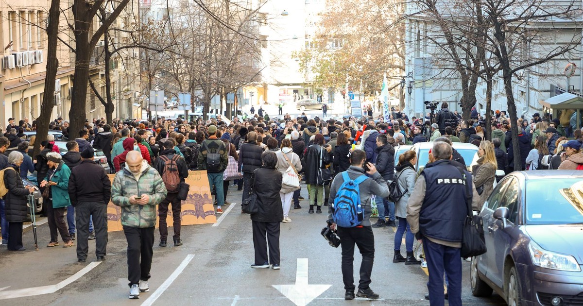 A large group of people gathered in an urban street for a city protest during the day.