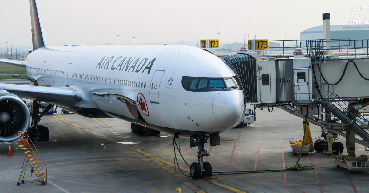 Air Canada aircraft at the gate, ready for passengers. Busy airport scene.