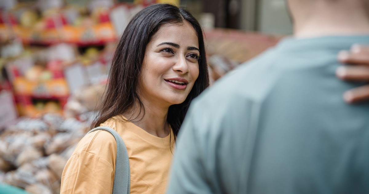 Smiling South Asian couple enjoying a day at the street market, engaging in conversation.