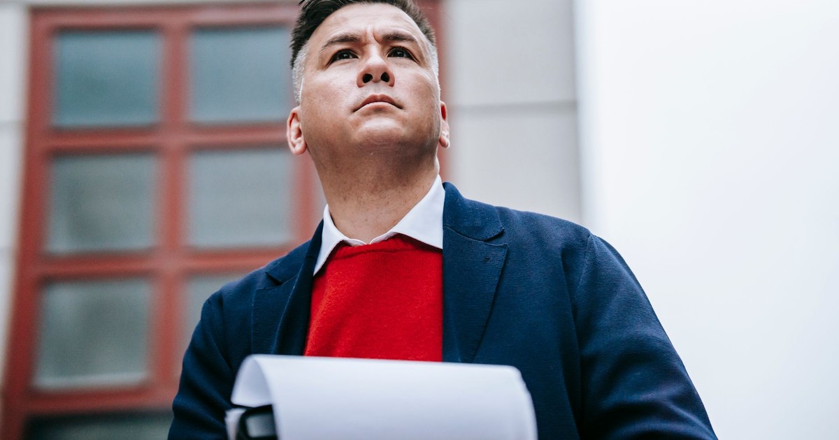 Business professional standing outdoors, confidently holding documents in a stylish outfit.