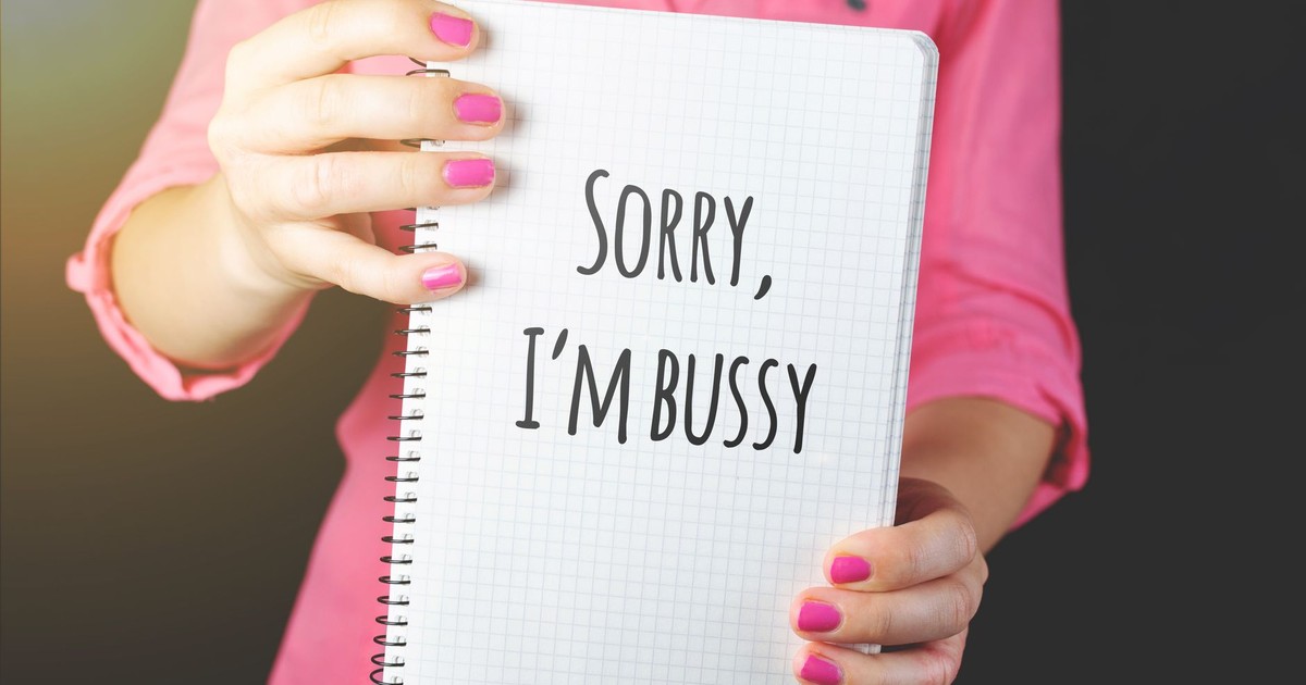 Woman holding a notebook with a handwritten message featuring a spelling error, showcasing humor and communication.