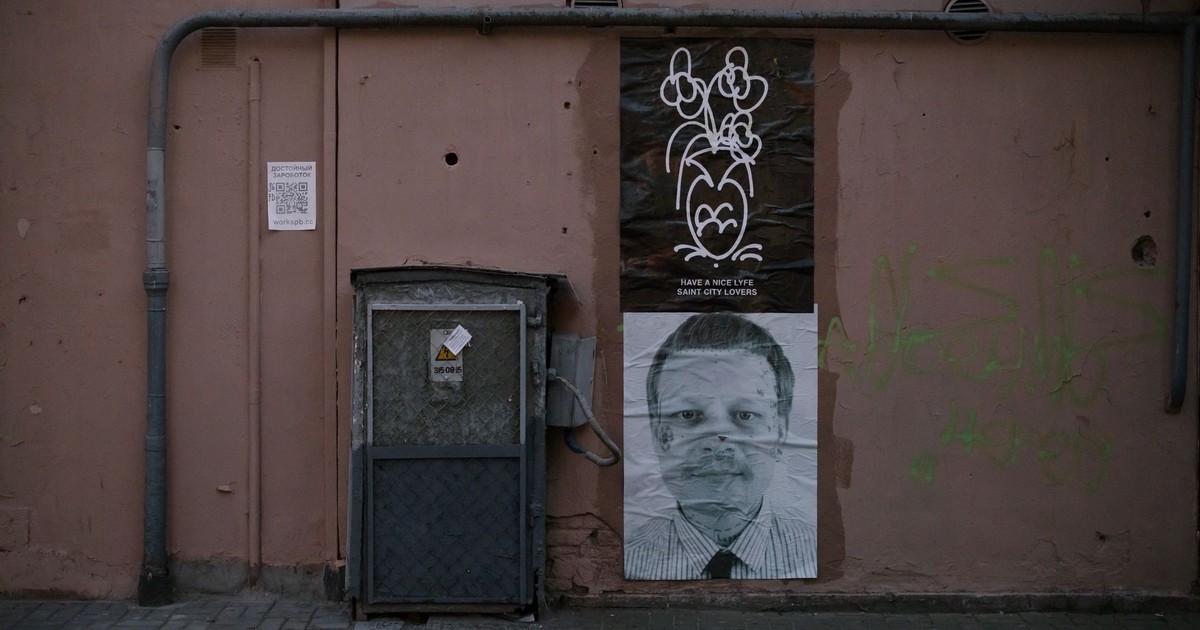 Street art and posters on a grungy urban wall, showcasing city life themes.