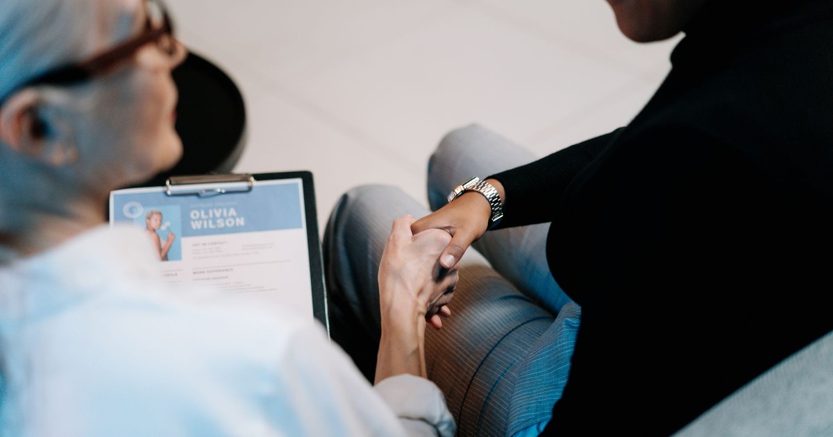 Two professional women having a handshake in an office setting, focusing on recruitment and connection.