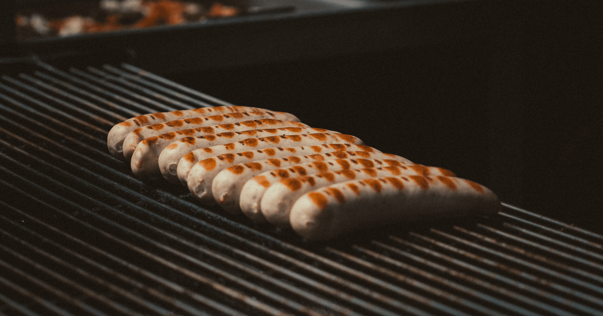 Close-up of delicious sausages grilling on a barbecue with perfect sear marks.