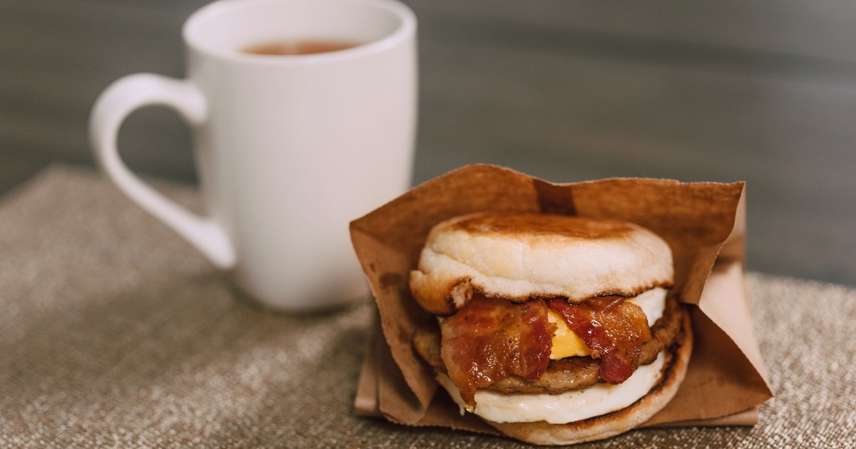 Delicious breakfast sandwich with bacon, cheese, and coffee for perfect morning start.