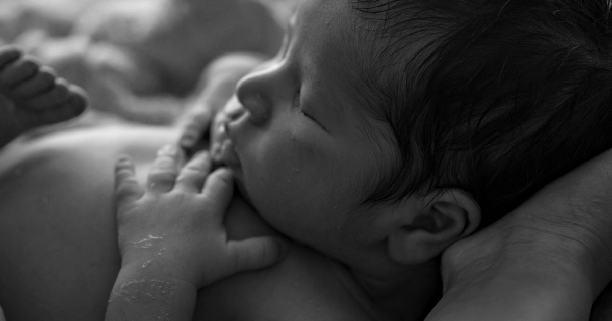 Close-up of a peaceful newborn baby sleeping, capturing tender moments in black and white.