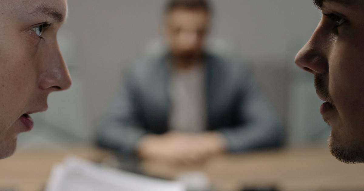 Close-up of two men in a serious discussion at a business meeting.