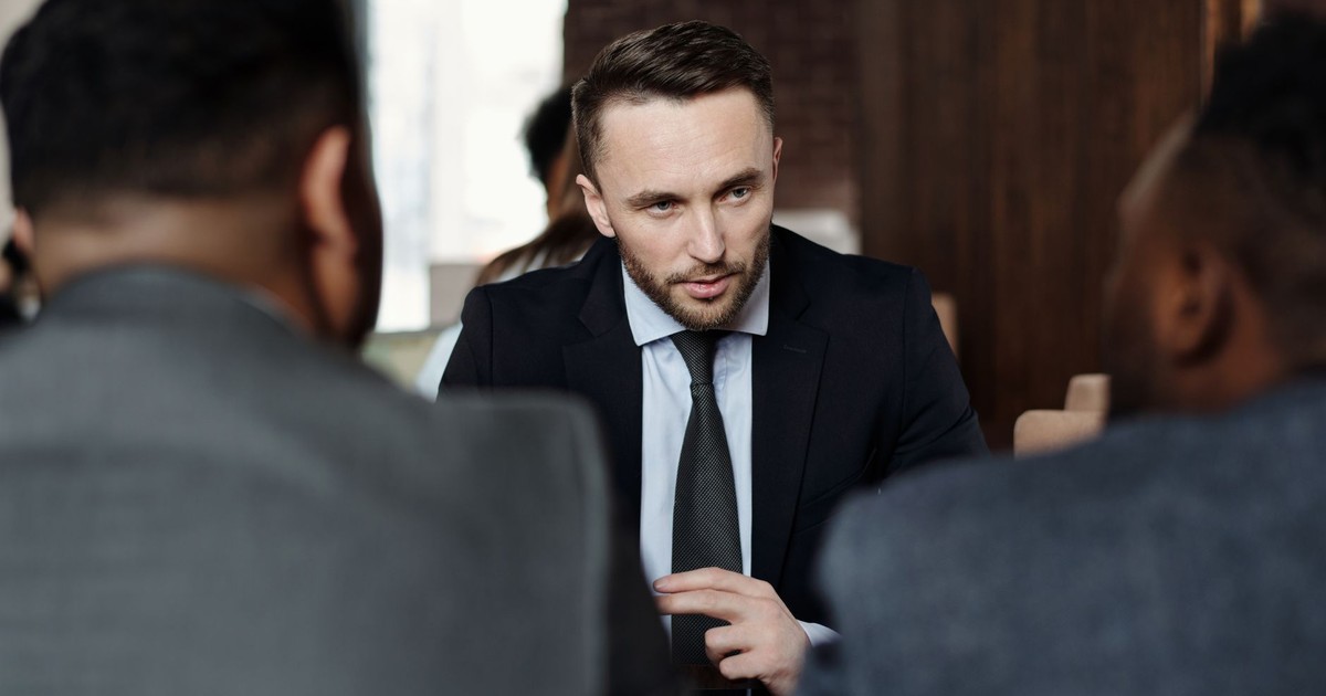 Business professionals in suits having a focused meeting indoors.