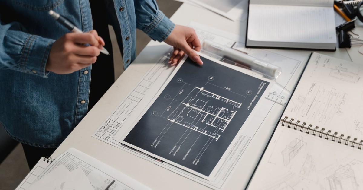 Engineer reviewing architectural blueprints on a desk with technical drawings.