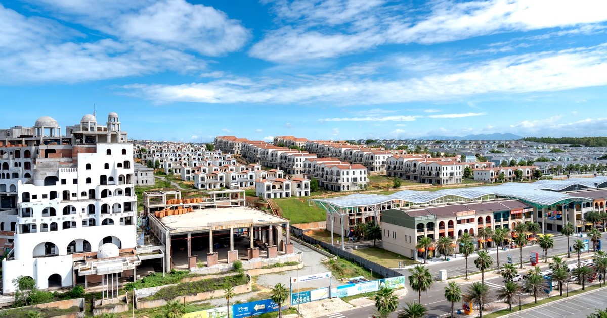 Aerial shot of a sprawling modern residential area under a bright blue sky.