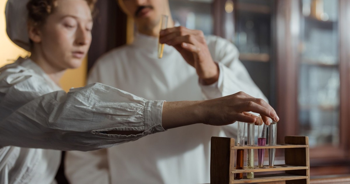 Researchers in a lab examining test tubes with colored liquids for experiments.