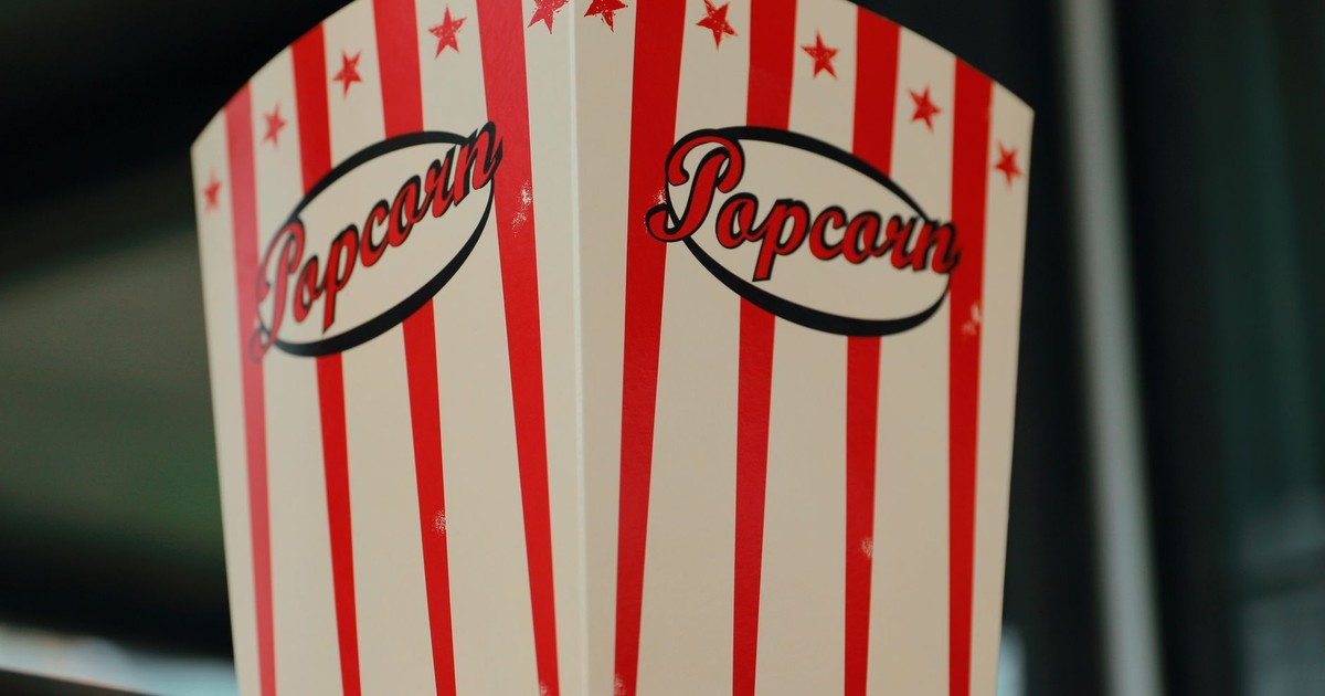 Red and white striped popcorn box indoors, perfect for cinema-themed settings.