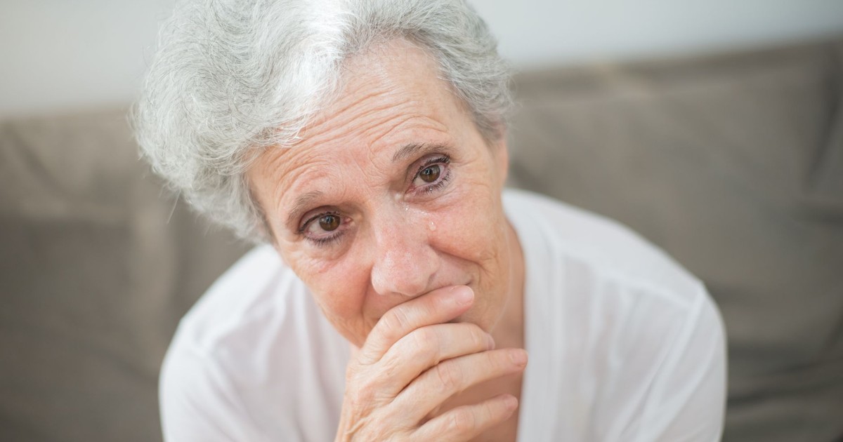 A thoughtful elderly woman with tears in her eyes, conveying deep emotions.