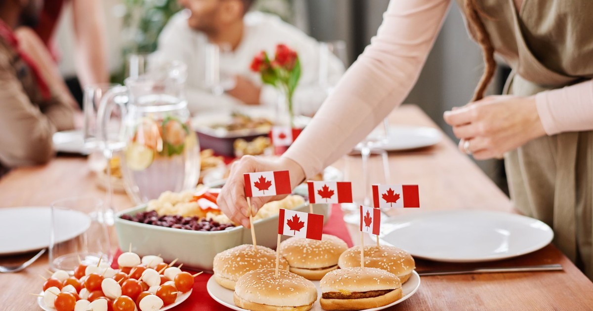 Festive Canadian dinner party scene with burgers, flags, and a lively gathering around the table.