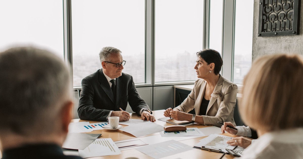Business professionals engaged in a strategic meeting in a modern office setting with natural light.