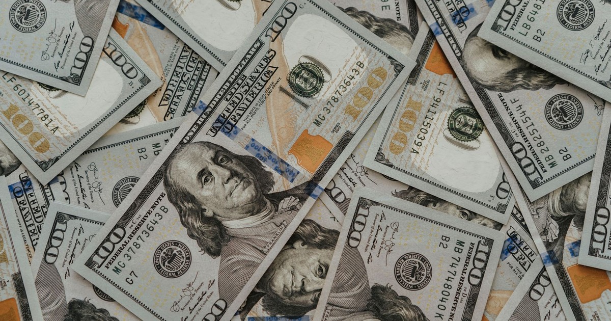Close-up of American 100 dollar bills scattered, highlighting wealth and currency concepts.