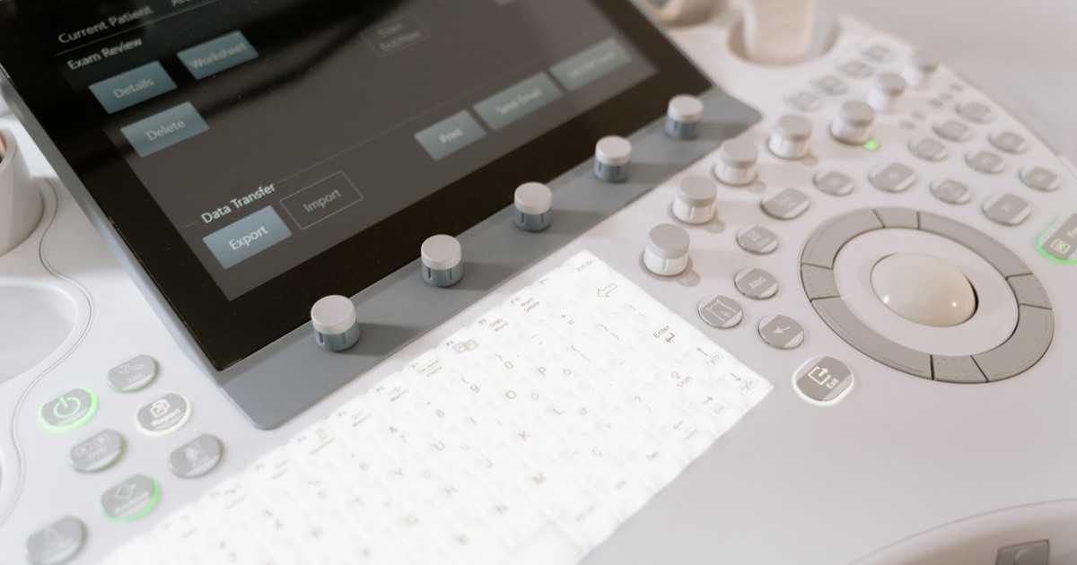 Detailed view of a medical ultrasound machine control panel with buttons and screen.