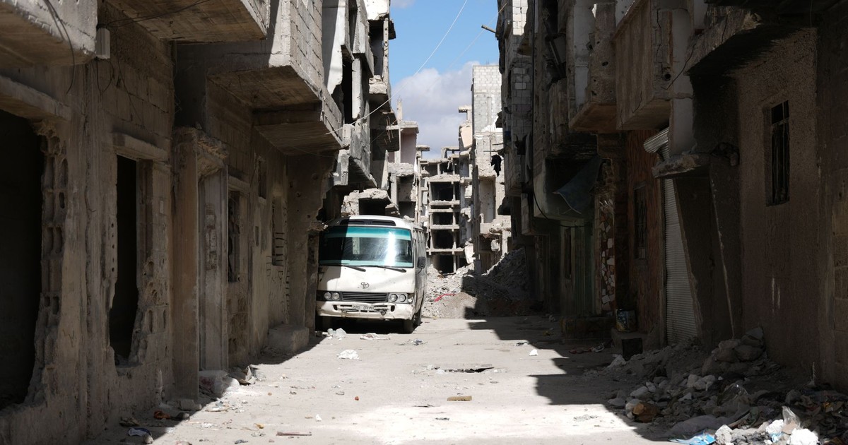 A desolate street in war-torn Damascus, showcasing abandoned buildings and debris.