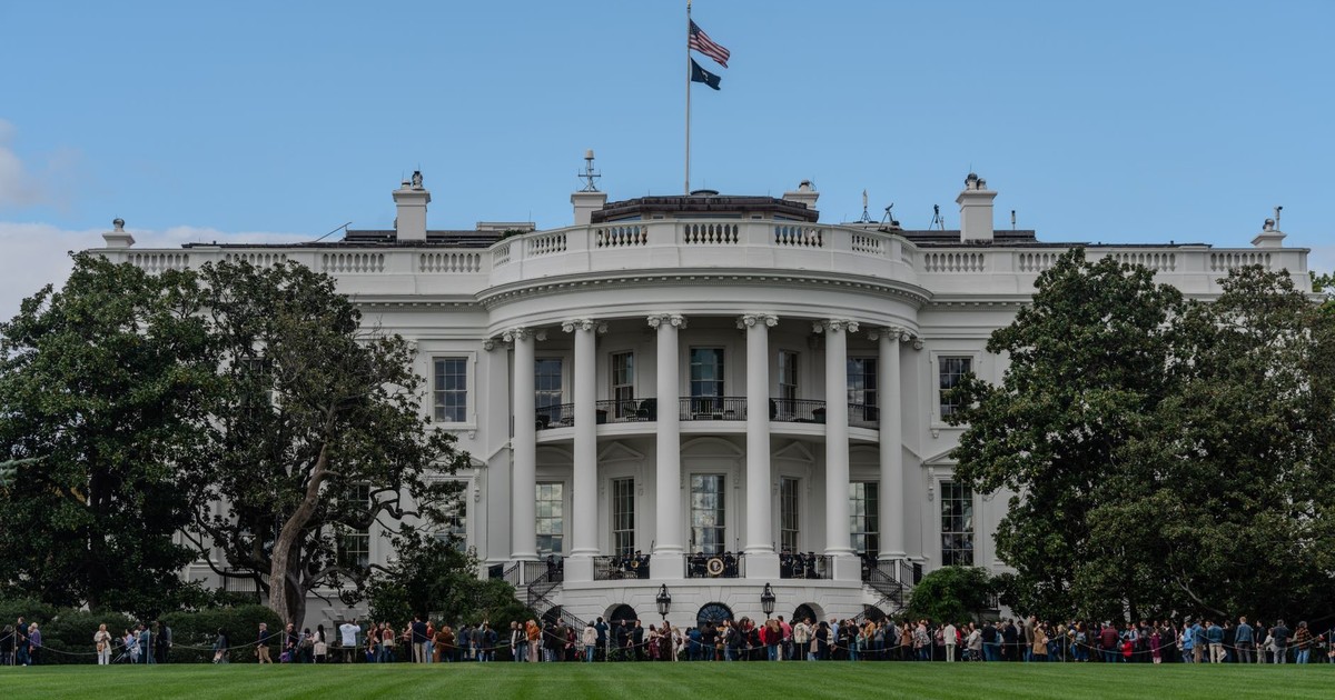 A picturesque view of the White House with the American flag in daylight.