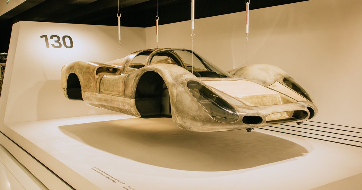 A classic car with sleek design showcased in a modern museum exhibition.