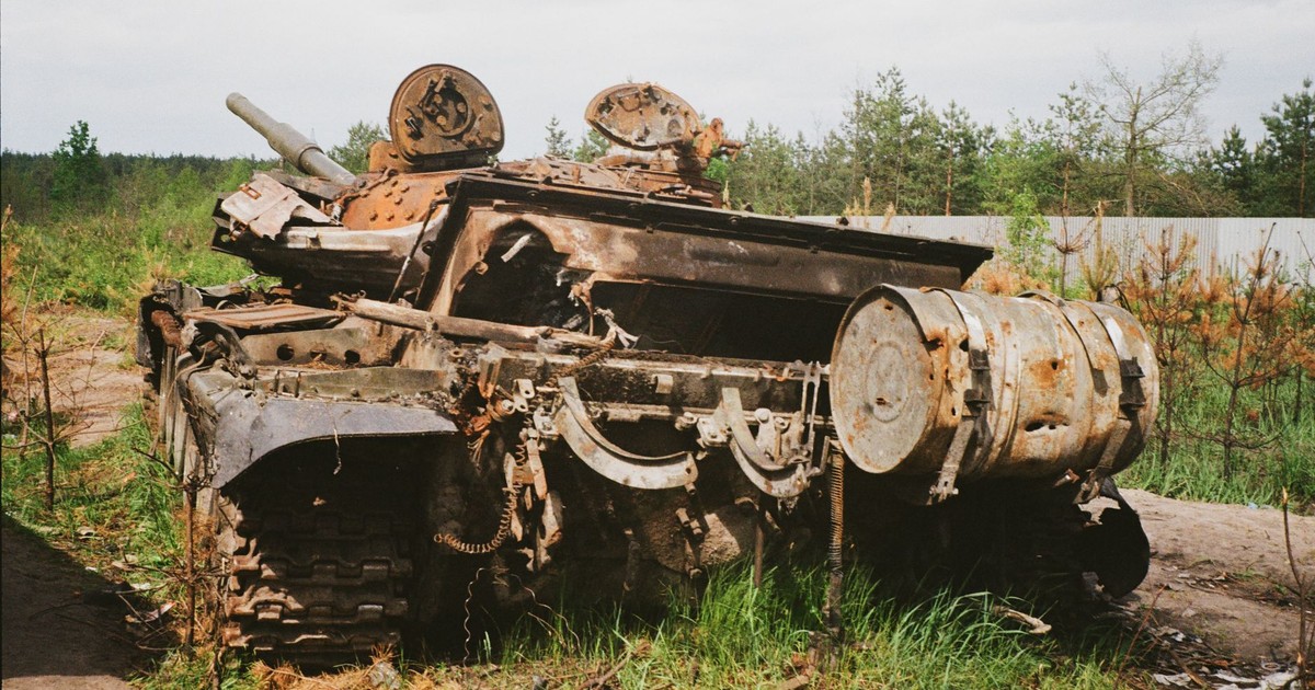 Rusted and damaged tank abandoned in Bucha, Ukraine, symbolizing conflict impact.