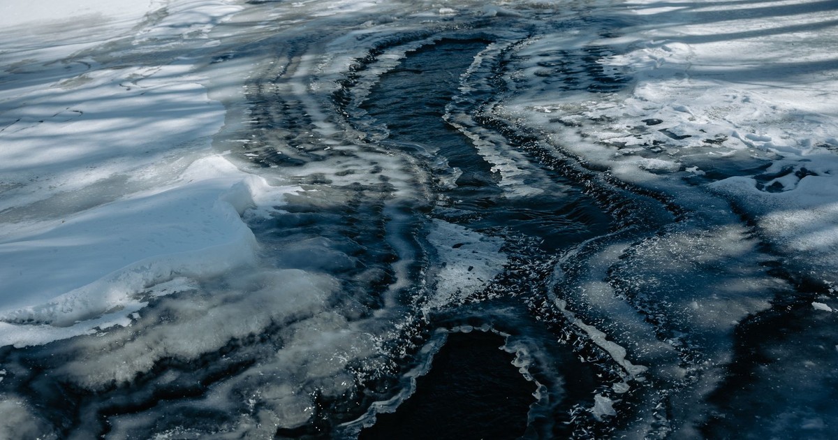 Abstract aerial view of a frozen river with striking ice melting patterns captured during winter.