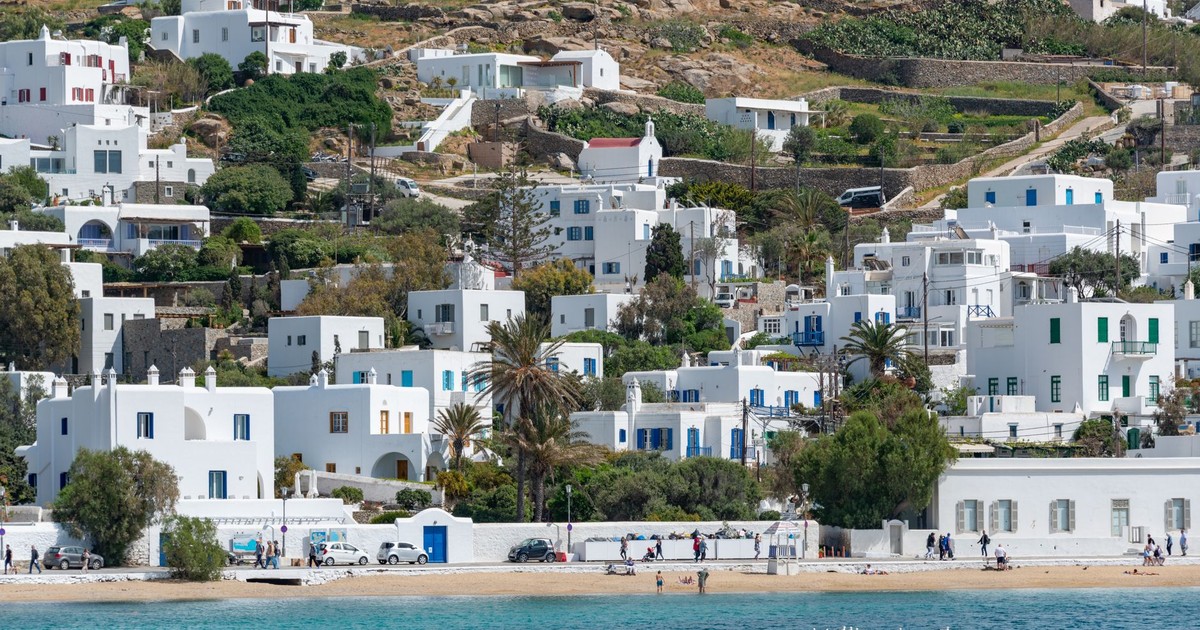 Beautiful Mykonos waterfront with iconic white houses and crystal-clear sea under bright summer skies.