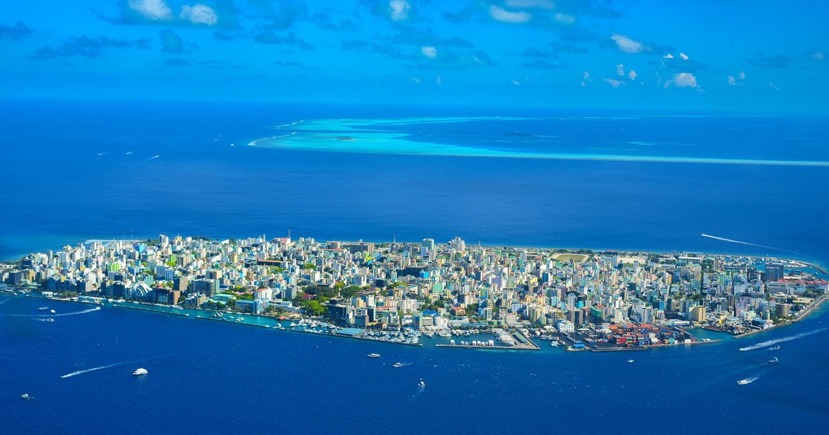Aerial photo of Malé Island, showcasing the dense cityscape surrounded by the vibrant blue ocean.