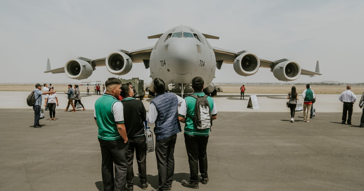A Boeing C-17 military aircraft displayed at an airfield event with people observing.