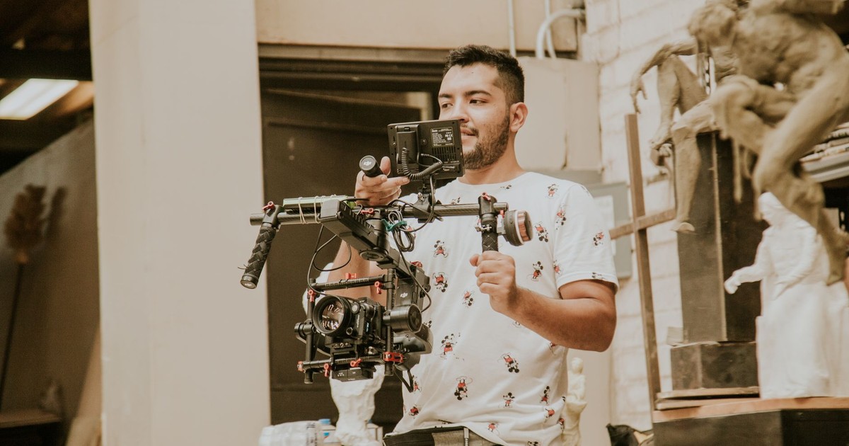 Videographer working with a professional stabilizing rig indoors, capturing behind-the-scenes moments.