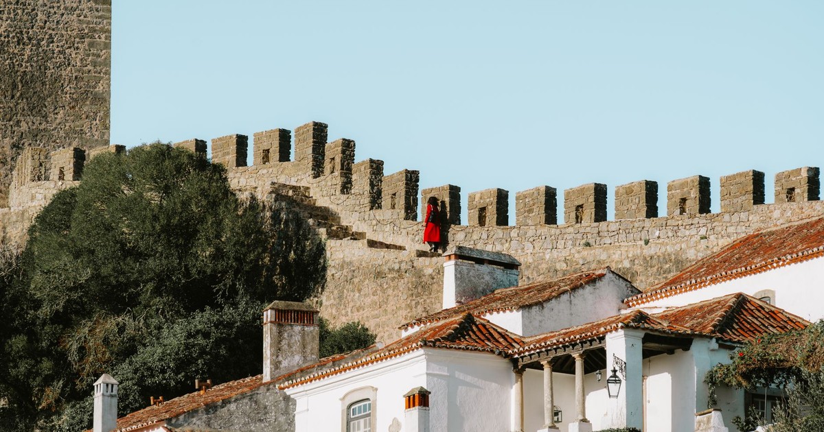 Obidos's historic walls and whitewashed buildings under a clear summer sky.