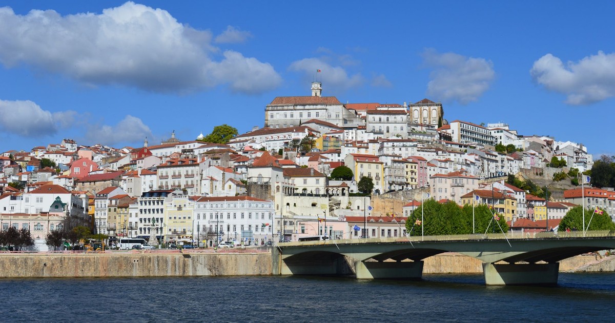 Panoramic view of Coimbra, Portugal showcasing historic architecture along the Mondego River.