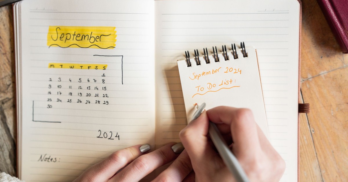 Close-up of a woman writing a to-do list for September 2024 in a notebook. Concept of organization.