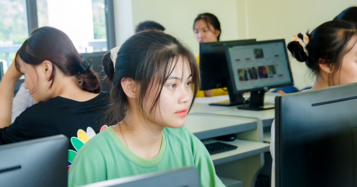 Asian students focused on studying technology in a bright computer classroom setting.