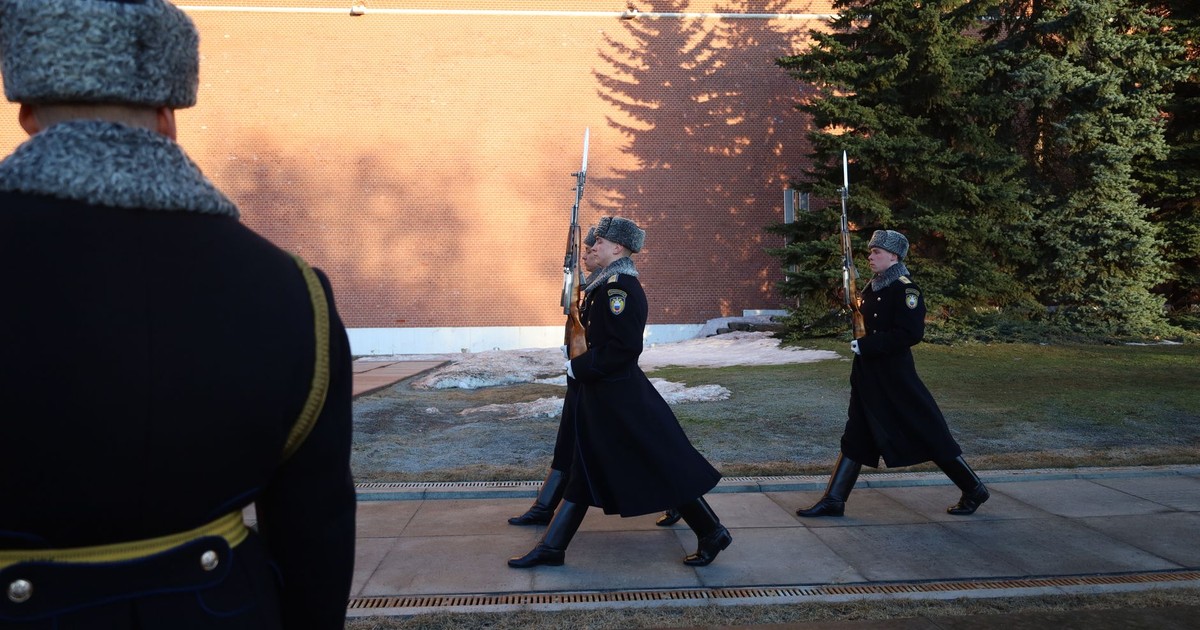 Ceremonial guards in winter uniforms march by Kremlin wall, Moscow.