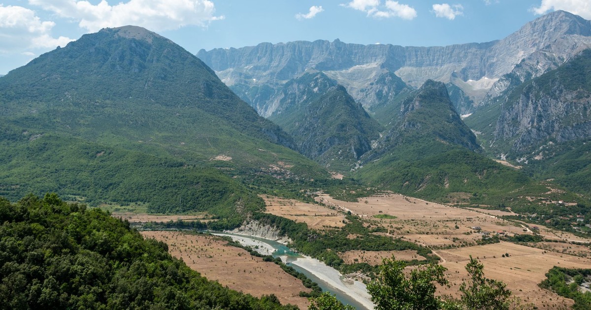 Aerial view of Përmet valley with lush greenery and majestic mountains in Albania.