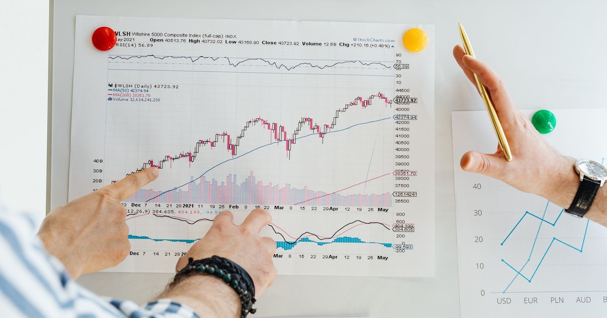 Two professionals analyze stock market graphs with a focus on finance and data trends.