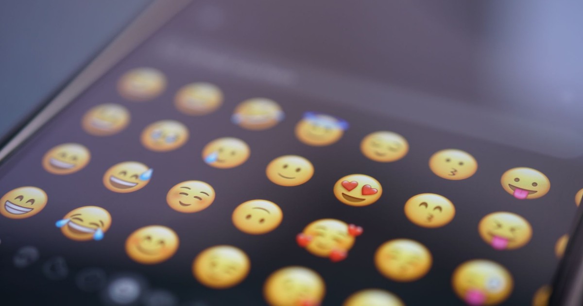A close-up view of various emojis on a smartphone screen, symbolizing digital communication and social media use.