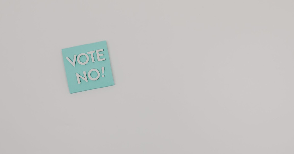 Simple image of a 'Vote No!' message on a gray surface with ample copy space.